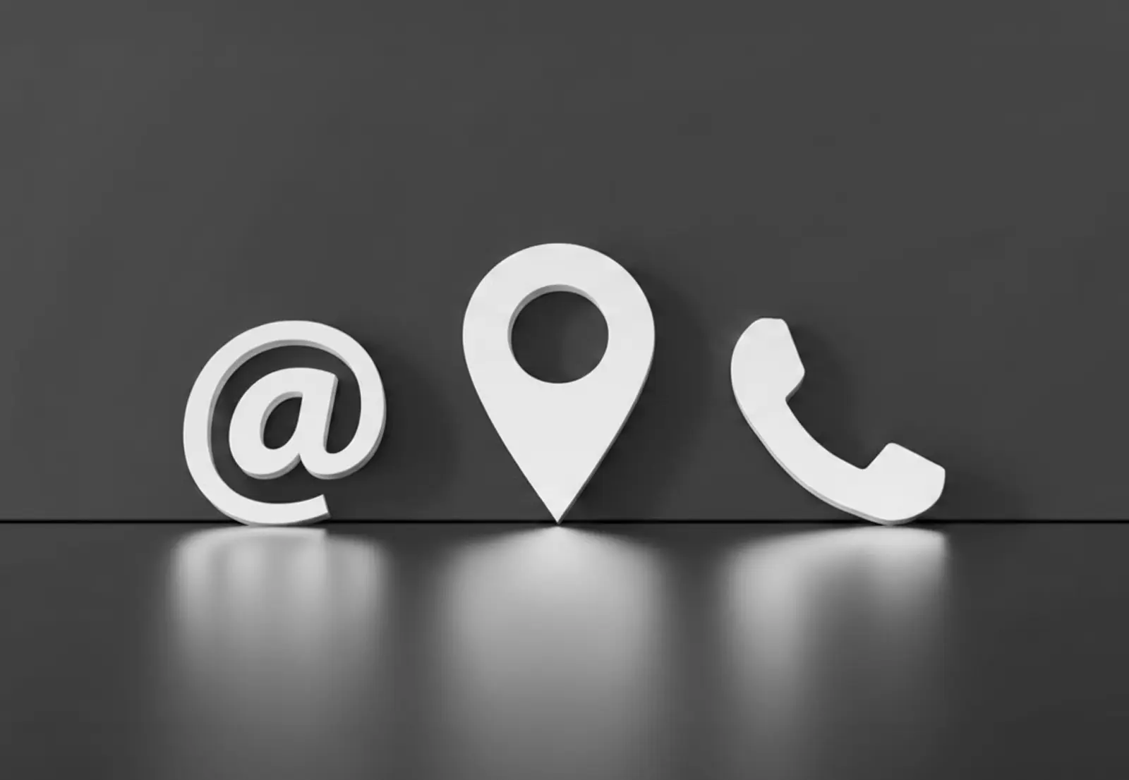 Dreidimensionale weiße Symbole für E-Mail (@), Standort-Pin und Telefon auf einer spiegelnden dunklen Oberfläche. Symbolische Darstellung der Kontaktmöglichkeiten.